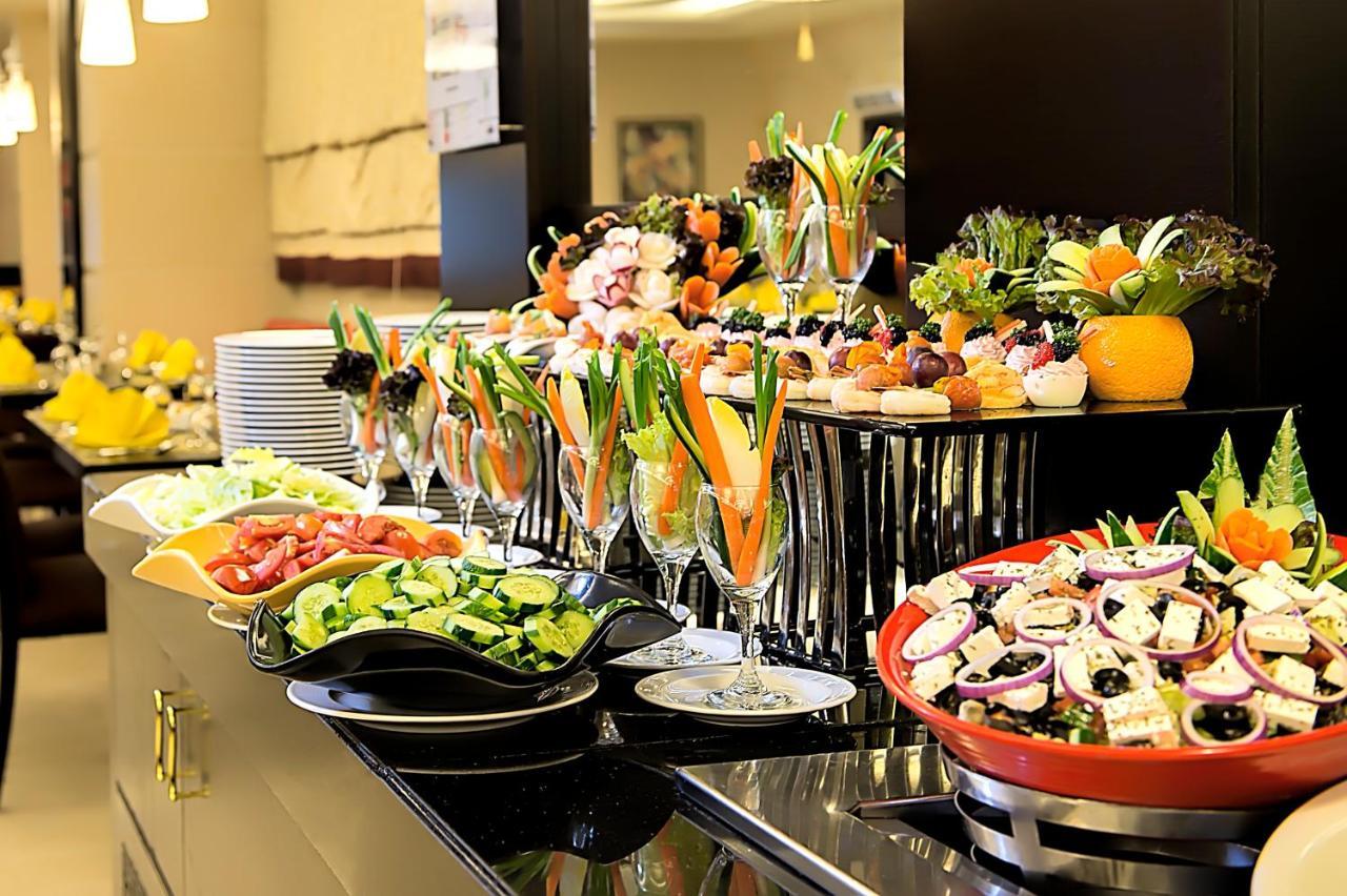 อัลคูฟราน ซาฟวะฮ์ โฮเต็ล มักกะฮ์ Hotel Mecca ภายนอก รูปภาพ The photo displays a beautifully arranged buffet featuring a variety of colorful and fresh food items. There are several plates and bowls filled with salads, including a mix of greens, chopped vegetables, and potentially some fruits. 

In the foregro